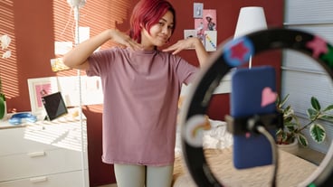 Happy female teenager boasting to her subscribers in front of smartphone