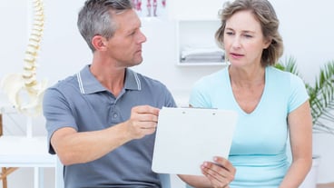 Physiotherapist showing his notes to his patient