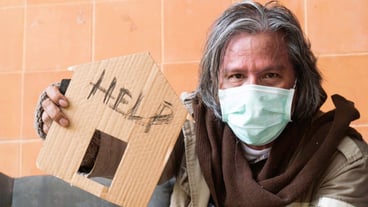 A homeless man with a sign asking for help