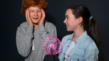 Medium shot kids interacting with a plasma ball