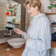 Woman holding pregnancy test confirming positive result in bathroom