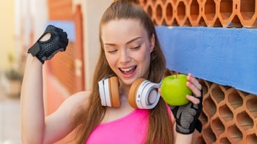 Young pretty sport girl with an apple at outdoors celebrating a victory