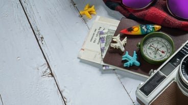 The camera and passport on wood table for travel concept.