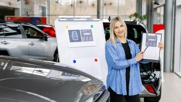 Saleswoman showing infographic during presentation about automotive suspension performance in car dealership