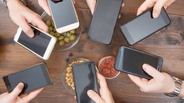 Top view of hands circling with phone in cafe