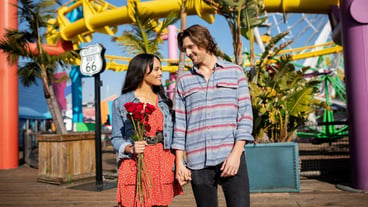 Front view of young couple at the amusement park having a date