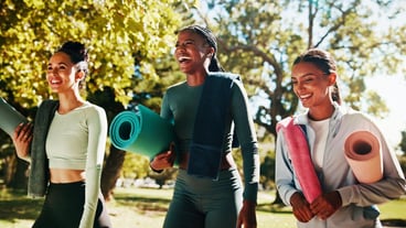 Friends yoga and women walking in park for workout exercise and practice for mobility in morning Nature pilates class and people laugh in conversation for wellness health and wellbeing on grass