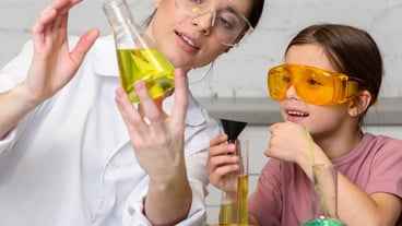 Female teacher and girl doing science experiments with test tubes