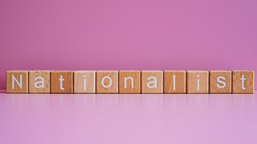 Wooden blocks form the text Nationalist against a pink background