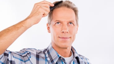 Handsome cheerful old man combing his hair