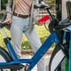 Side view of unrecognizable woman using her smartphone to rent a bicycle from the bike rental station to ride around the city.