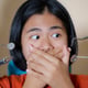 Girl frightened by dentist covers her mouth at dental clinic