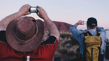 Rear view of men photographing on landscape