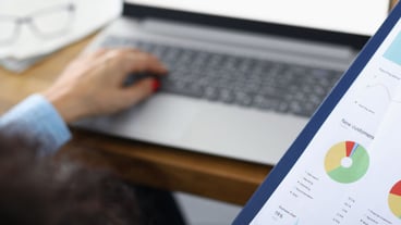 A business woman sits at a laptop and looks at a statistical report financial planning and
