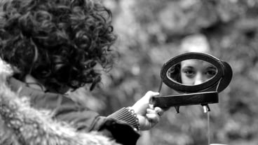 Portrait of woman holding mirror outdoors