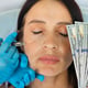 Woman receives antiaging injections in face holding US dollar bills