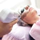A woman lying couch is undergoing a carbon facial peeling procedure