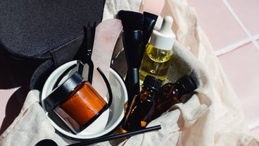 Black cosmetic necessary bag with a set of travel size miniature beauty facial products like oil