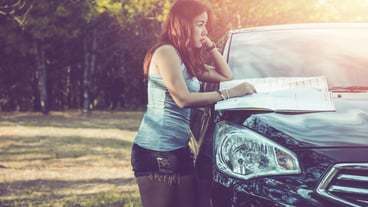 Side view of woman standing by car