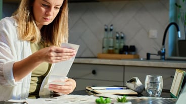 Woman planning home budget analyzing financial bills in kitchen