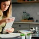Woman planning home budget analyzing financial bills in kitchen