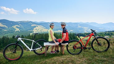 Couple sportsman near bicycles in mountains
