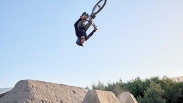 Mountain bike and cyclist man riding bicycle for a dangerous risk stunt Fitness adrenaline junkie and extreme sports with a healthy biker jumping for a trick on his bike for adventure and fun