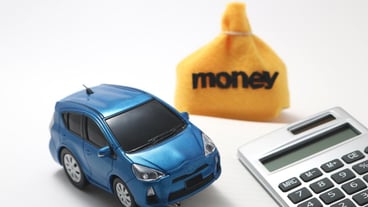 Toy car and calculator against white background
