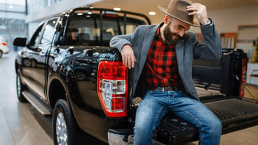 Happy man poses in the back of new pickup truck