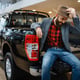 Happy man poses in the back of new pickup truck