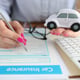 Woman holding toy car in her hands and filling out insurance form closeup