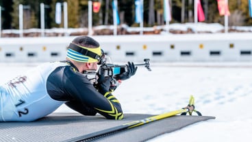 Biathlete shooting with a rifle at a shooting range at the race