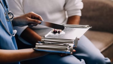 Doctor and patient sitting and talking at medical examination at hospital office closeup Therapist filling up medication history records Medicine and healthcare concept