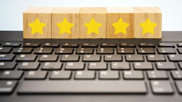 5 stars rating on wood block on top of computer keyboard