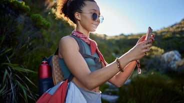 Travel sunglasses and woman with smartphone in nature for hiking route gps navigation or direction Smile mobile phone and female person with eyewear for adventure sightseeing or explore outdoor