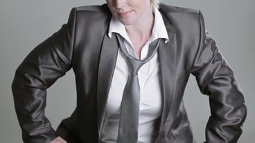 Glamorous woman in a pantsuit isolated on gray background
