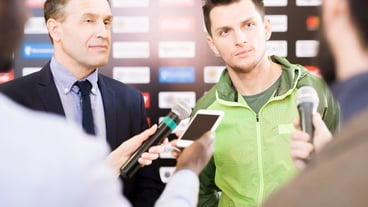 Young sportsman and coach at press conference