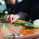 Coffin flower and hand at memorial with respect grief or loss at family service for burial Person mourning and grieving relative with white rose on casket for remembrance at funeral at graveyard