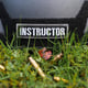 Instructor tactical black helmet with the inscription instructor lies on the grass with rifle shells
