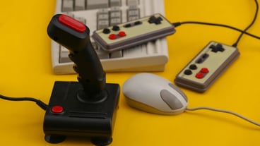 Old keyboard, joystick, gamepad and mouse on blue background. Retro gaming. 80s.