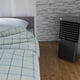 black mobile air conditioner in a room with a bed 3d