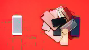 Choice of multicolored plastic back covers for mobile phones on red background with a smart phone on the side