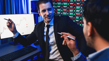Two stock exchange traders discussing on dynamic investment graph sellable