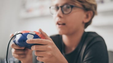 Close-up of cute boy playing video game at home