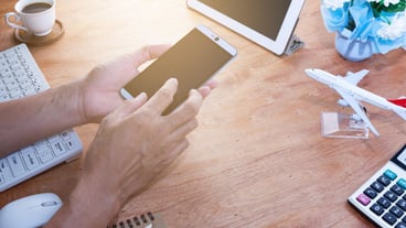 Severed hand using phone on tabletop