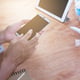 Severed hand using phone on tabletop