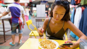 Woman eating Pad Thai noodles at Khao San road