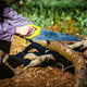 Man sawing wood for campfire in the forest.