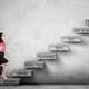 Caucasian business woman looking up ready to climb the success staircase
