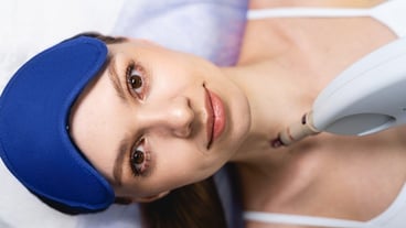 Top view of a beautiful young woman lying on the couch during the laser treatment